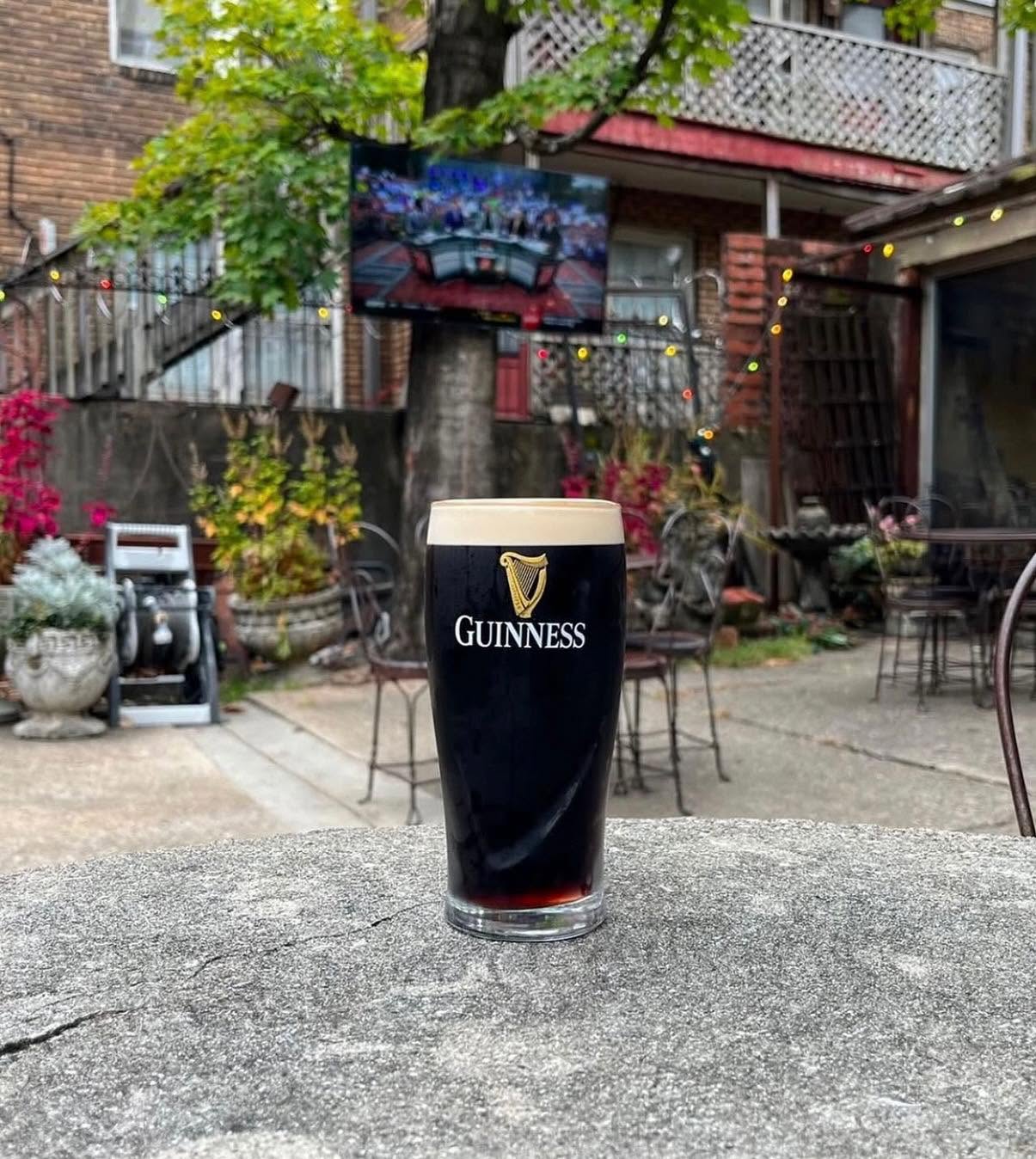 A pint of Guinness on a stone table in The Garage courtyard